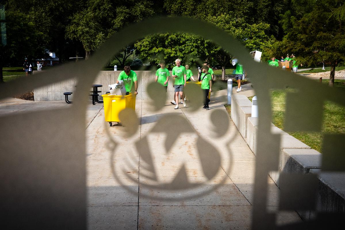 Members of the Cat Crew, identified by their bright green shirts, help move students into the residence halls