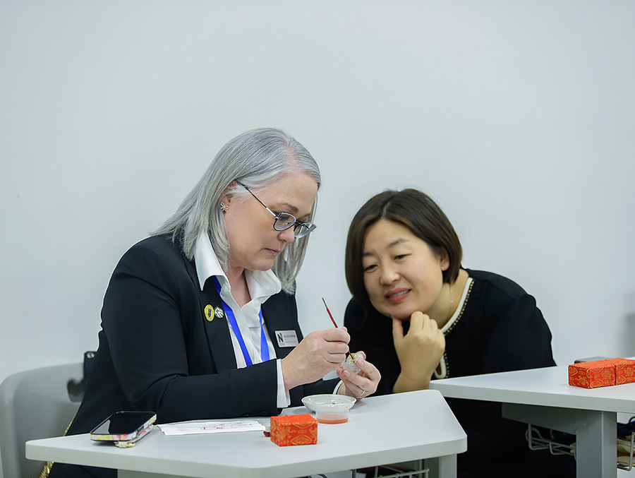 Dr. Elise Hepworth practiced the Chinese art of bottle painting with a delegate of Hebei Normal University. (Photo courtesy of Dr. Shelby Lee/GCBEI)