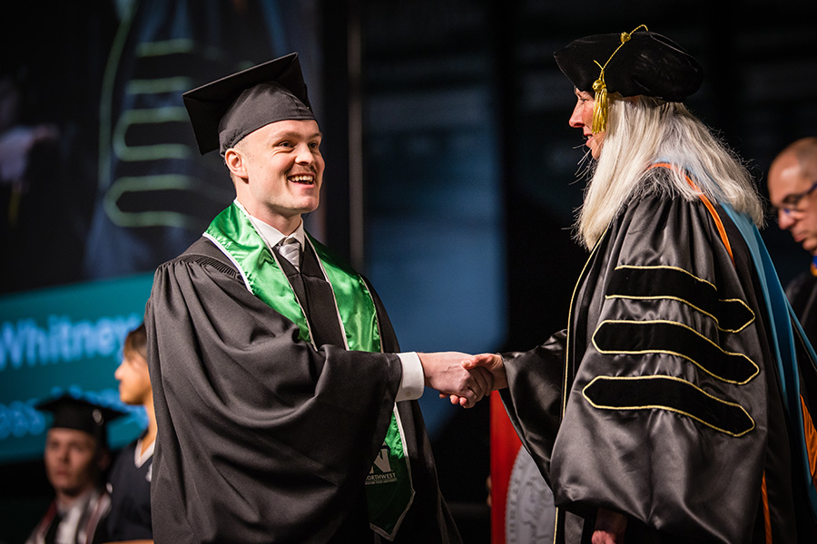 Northwest Provost Dr. Jamie Hooyman congratulates a graduate as he crosses the commencement stage in December. (Photo by Todd Weddle/Northwest Missouri State University)