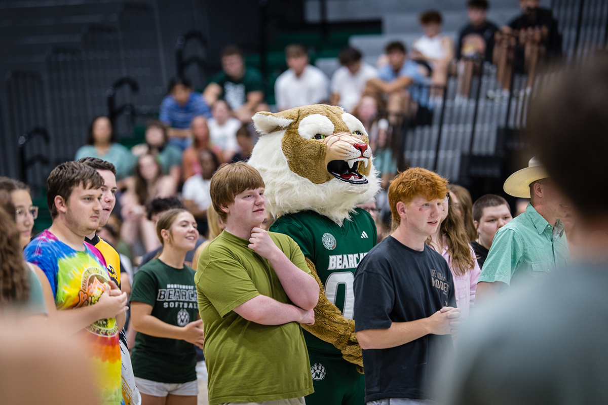 Bobby Bearcat and first-year students contemplate a question about President Tatum's interests during a game at the new student convocation in Bearcat Arena. Students played games for prizes in addition to hearing from academic leaders and the Bearcat Marching Band before participating in the annual March to the Tower. (Photo by Lilly Cook | Northwest Missouri State University)