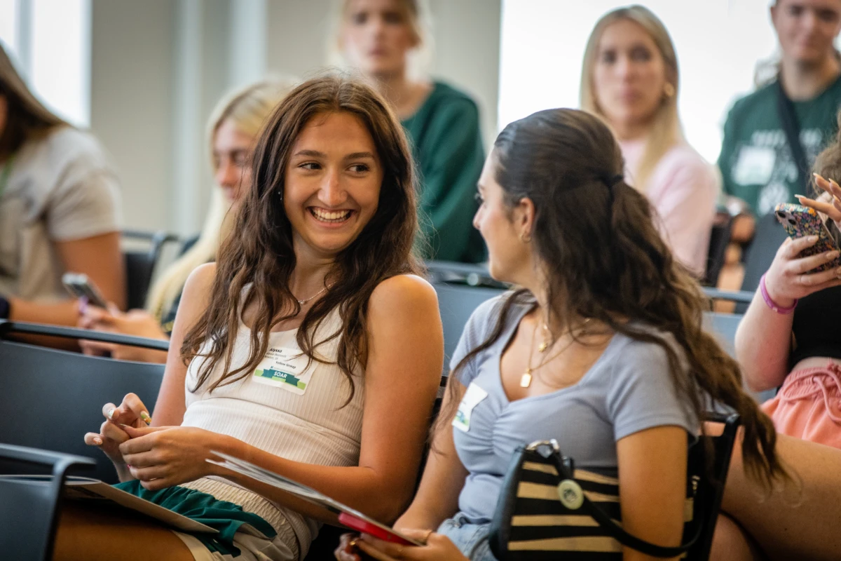 Two students chat before the new student session.