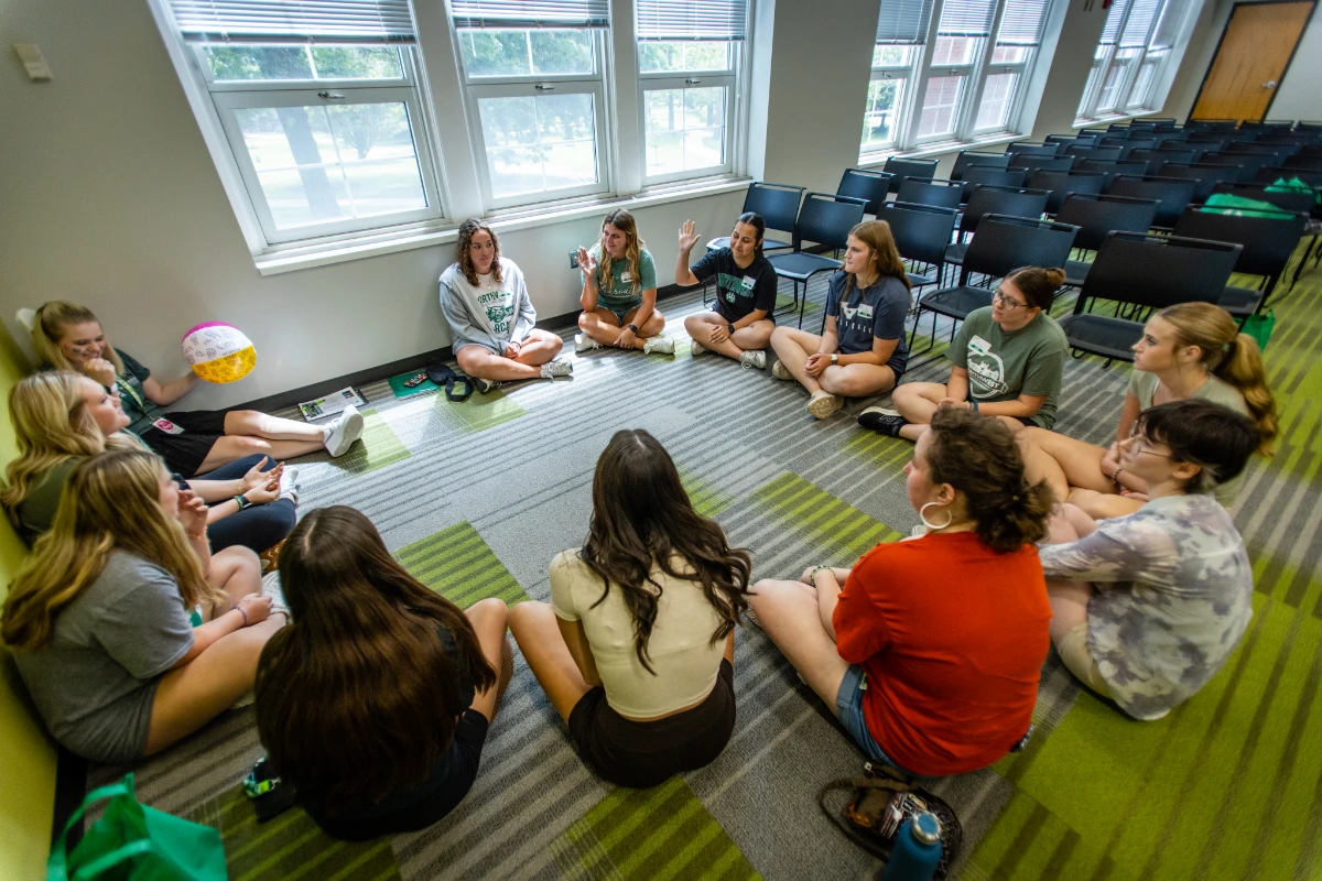 Students gather in a circle and participate in an icebreaker activity to get to know each other within their major groups.